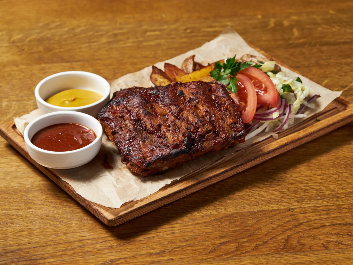 Пивные рёбра BBQ по фирменному рецепту, подаются с горчицей и пряным картофелем в бар Pivzavod77